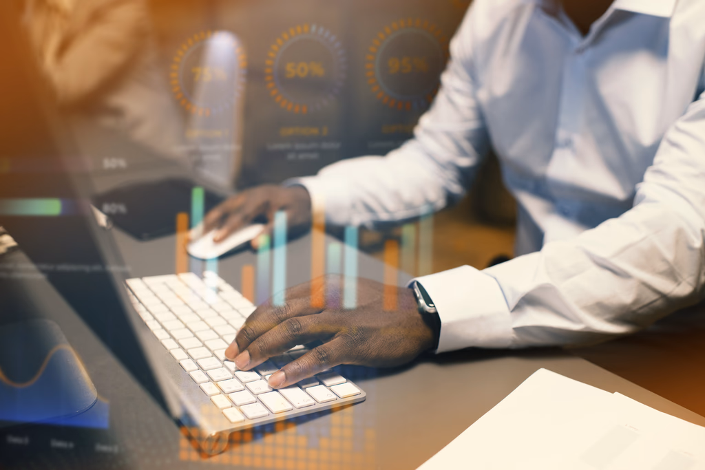Hands typing on a keyboard beside analytics charts